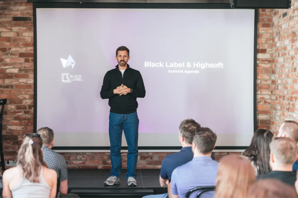 The CEO is standing on the stage and leading a meeting.